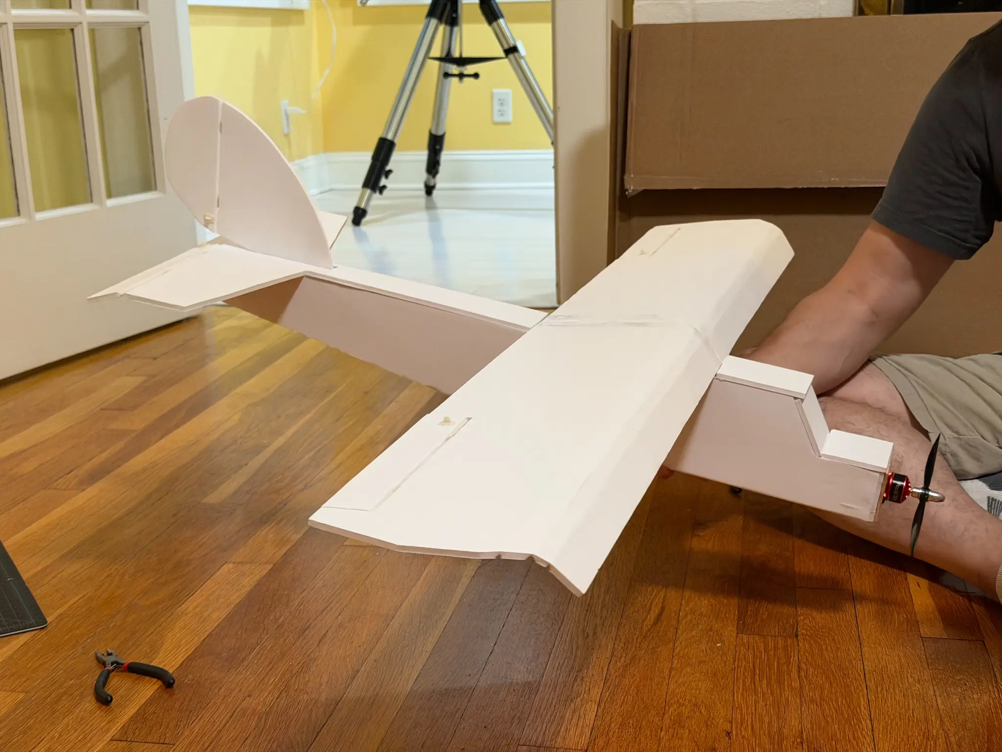 Fully assembled foam-board aircraft held during final inspection.
