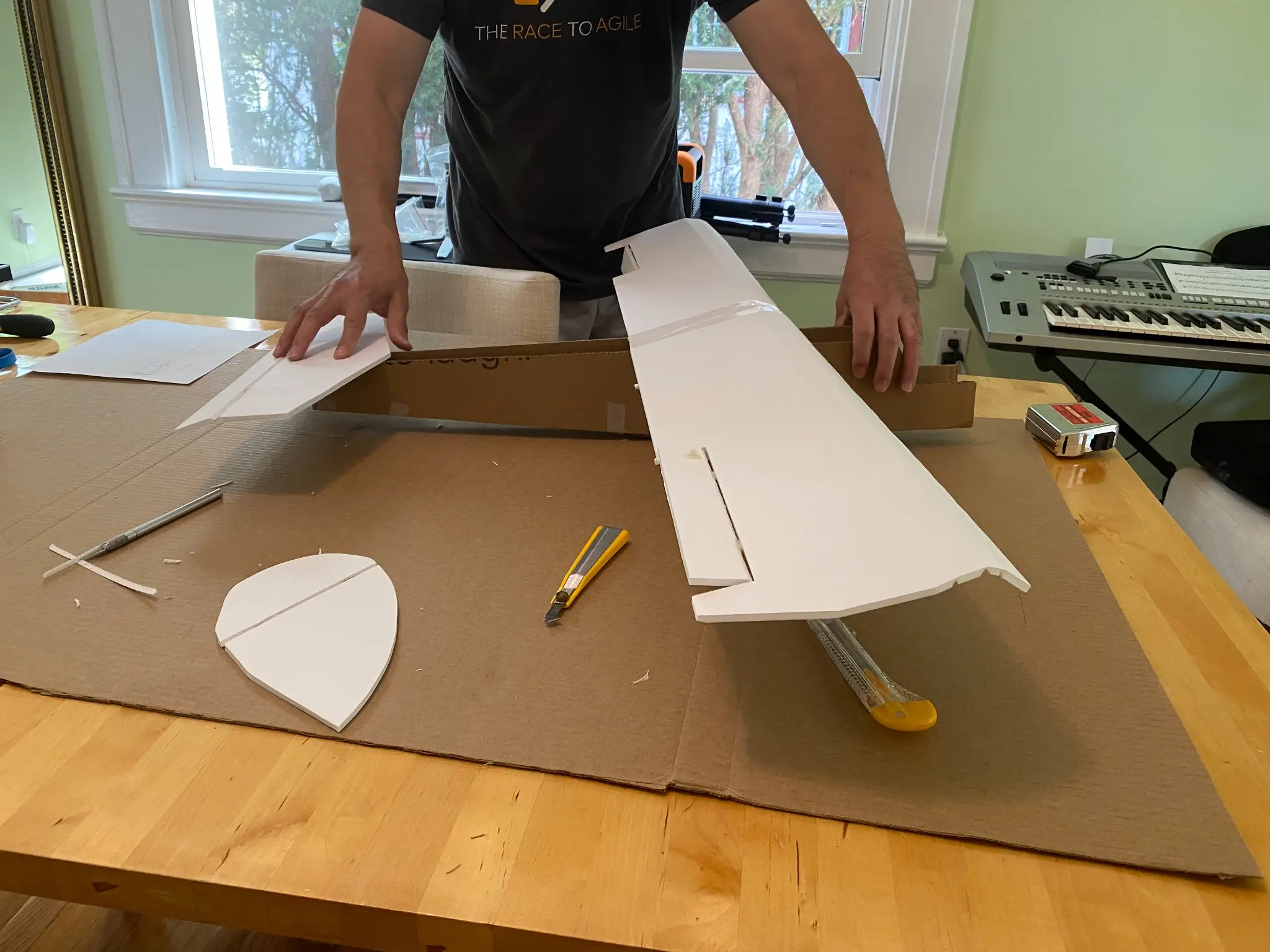 Marcus fabricating the foam-board wing and airframe components at a worktable.