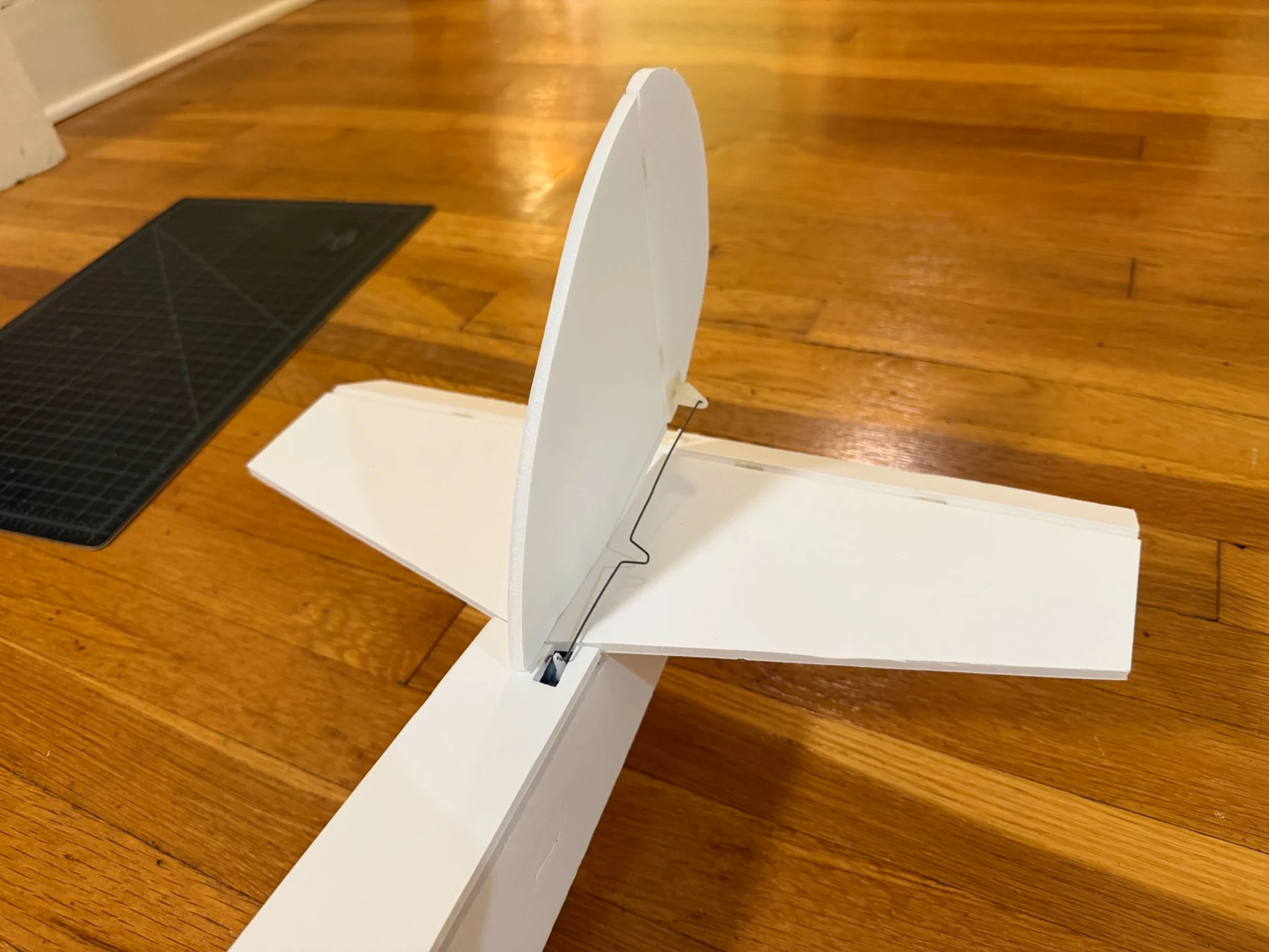 Close-up of the aircraft tail showing the fin, stabilizer, and control linkage.