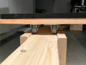 Small wheels underneath the rolling seat on wooden rails.