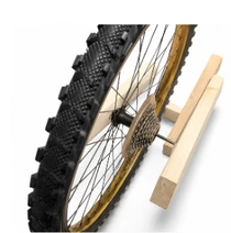 Close view of the bicycle wheel integrated into the wooden frame.